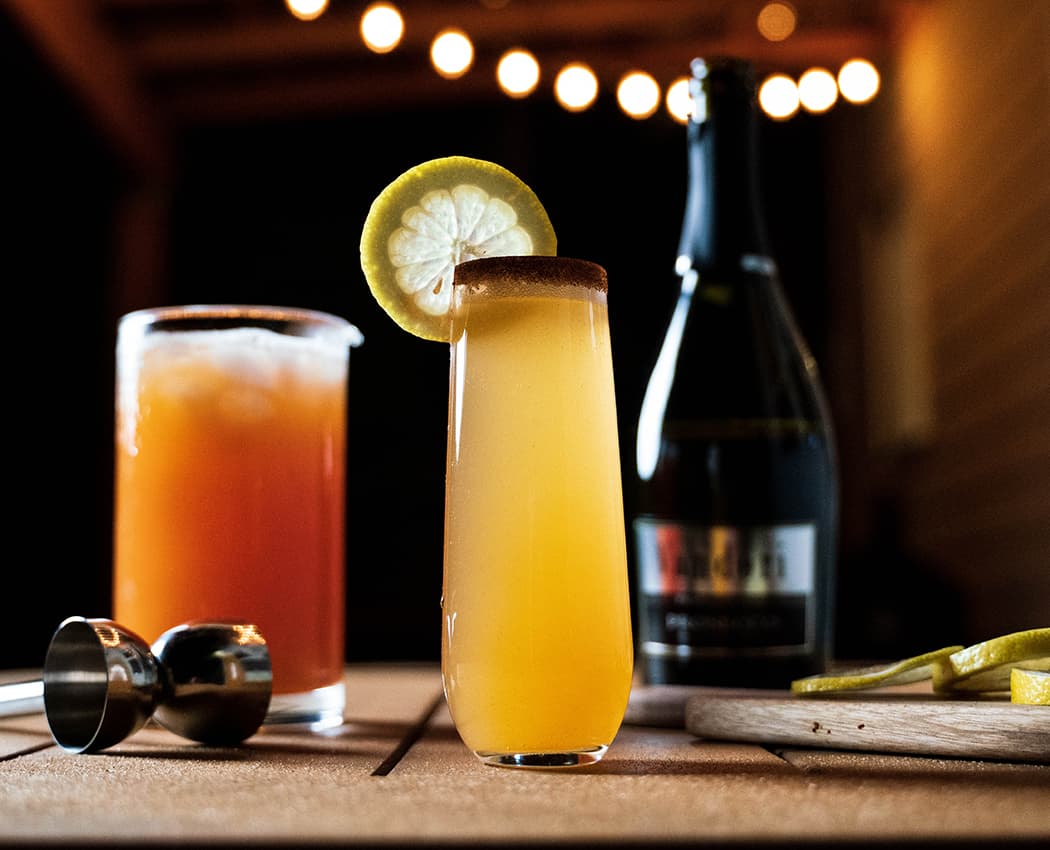 Apple Fizz cocktail served in a champagne glass with lemon.